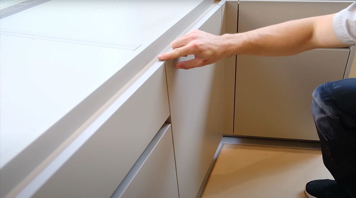 eggersmann installer inspecting accuracy of cabinet door alignment on a luxury home renovation job site