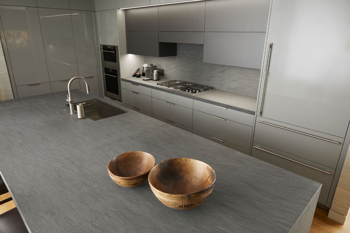island made of eggersmann's unique cabinetry collection in carbono waterjet quartzite in a dallas museum tower residence's kitchen island made of eggersmann's unique cabinetry collection in carbono waterjet quartzite wolf cooking appliances in a dallas museum tower residence's kitchen