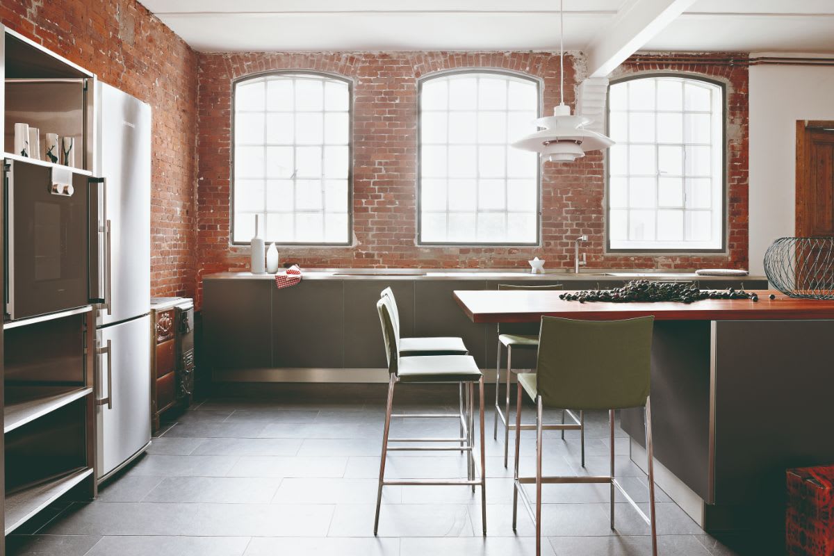 sherwin williams color of the year 2024 featured in an eggersmann-designed uxury kitchen with exposed brick and arched windows