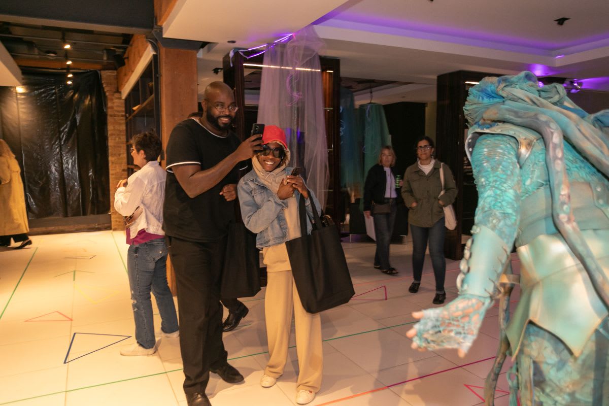 surprised guests take pictures of the living statue in the eggersmann chicago showroom during the rndd 2023 gallery walk