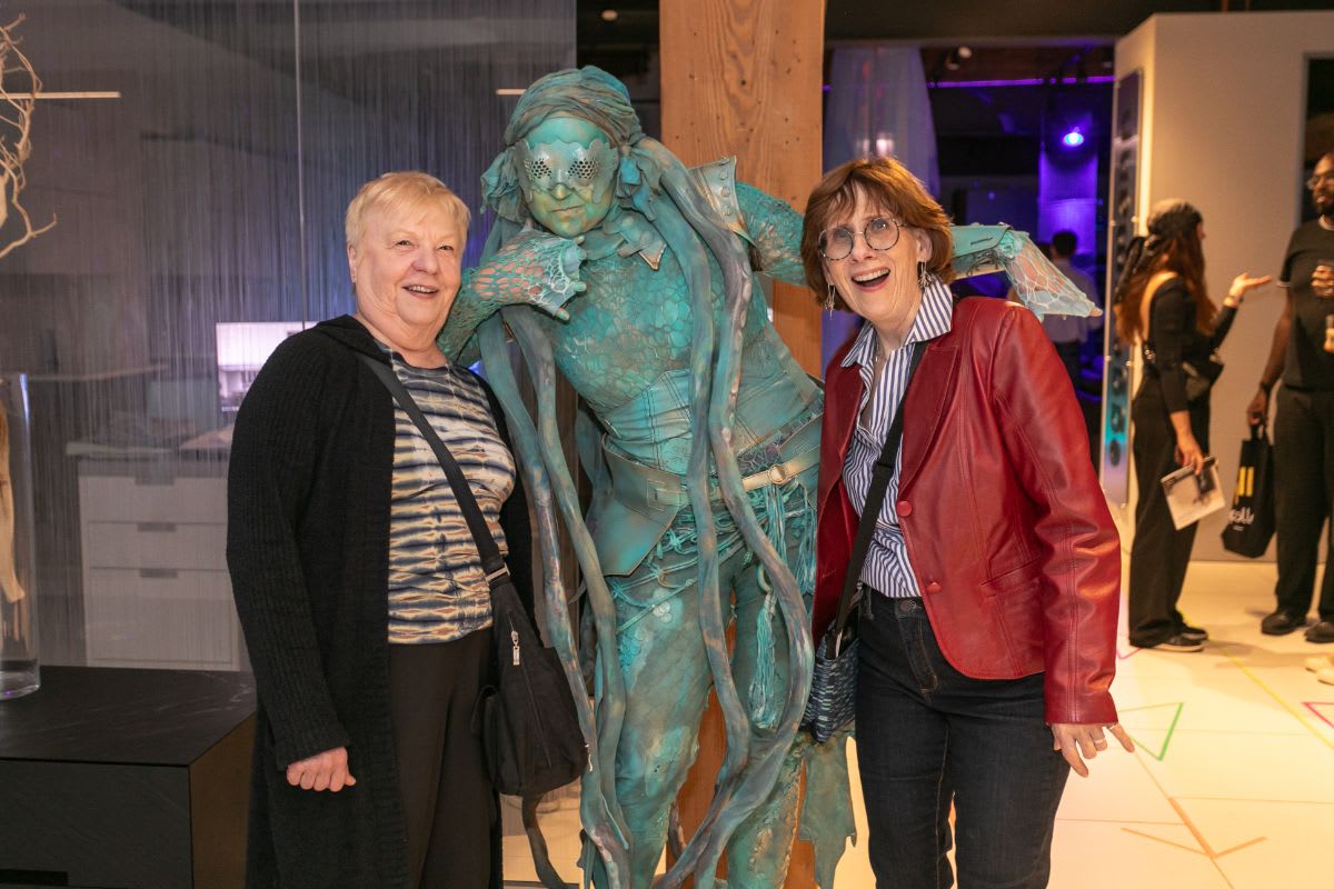 guests happily pose with the living statue in the eggersmann chicago showroom during the rndd 2023 gallery walk
