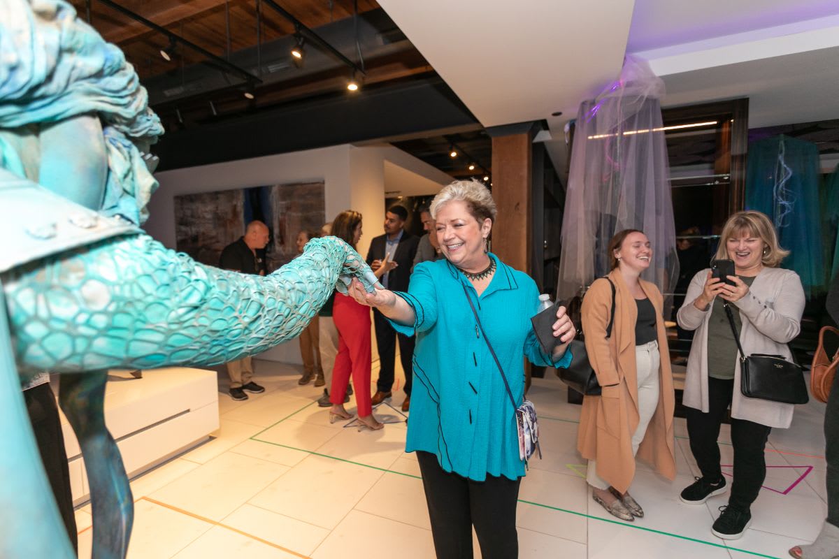 guest accepts a friendly gesture from the the living statue in the eggersmann chicago showroom during the rndd 2023 gallery walk