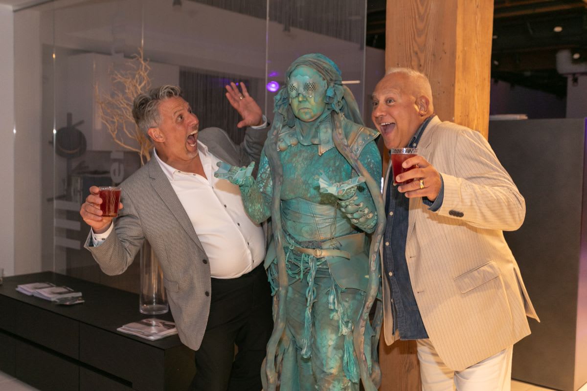 guests pose feigning surprise with the living statue in the eggersmann chicago showroom during the rndd 2023 gallery walk