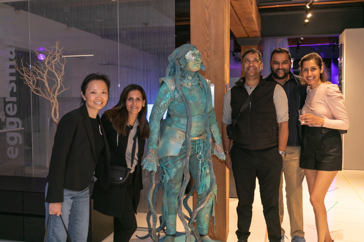 a group of guests posed with the living statue in the eggersmann chicago showroom during the rndd 2023 gallery walk