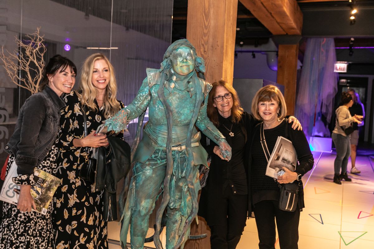 4 tickled guests pose with the living statue in the eggersmann chicago showroom during the rndd 2023 gallery walk
