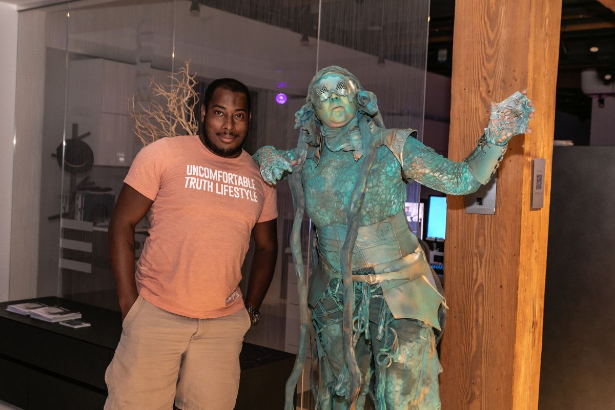 an unsure guest poses with the living statue in the eggersmann chicago showroom during the rndd 2023 gallery walk
