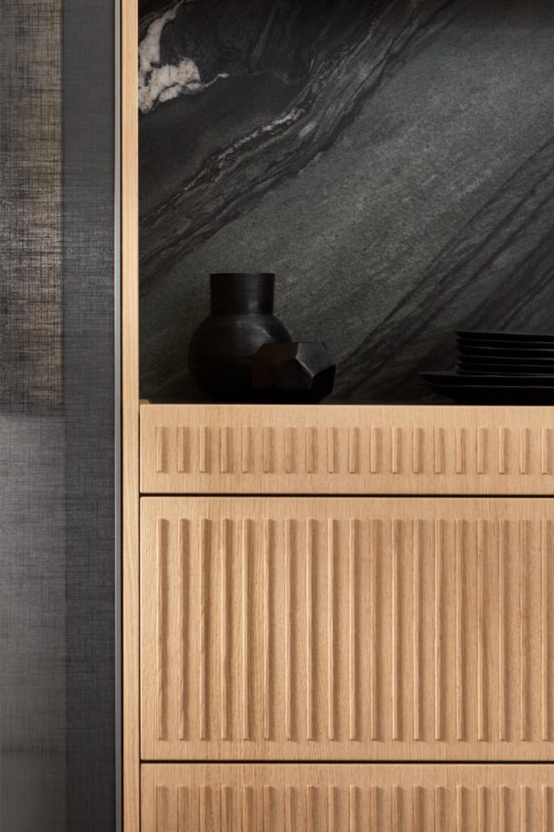 osaka tamboured veneer drawer front details with textural cabinet fronts and marble backsplash featured in kitchen wall cabinetry that accompanies the eggersmann nami kitchen island