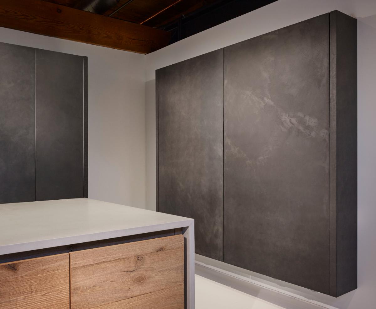 closeup of dark grey wall-mounted cabinet unit with coplanar doors closed