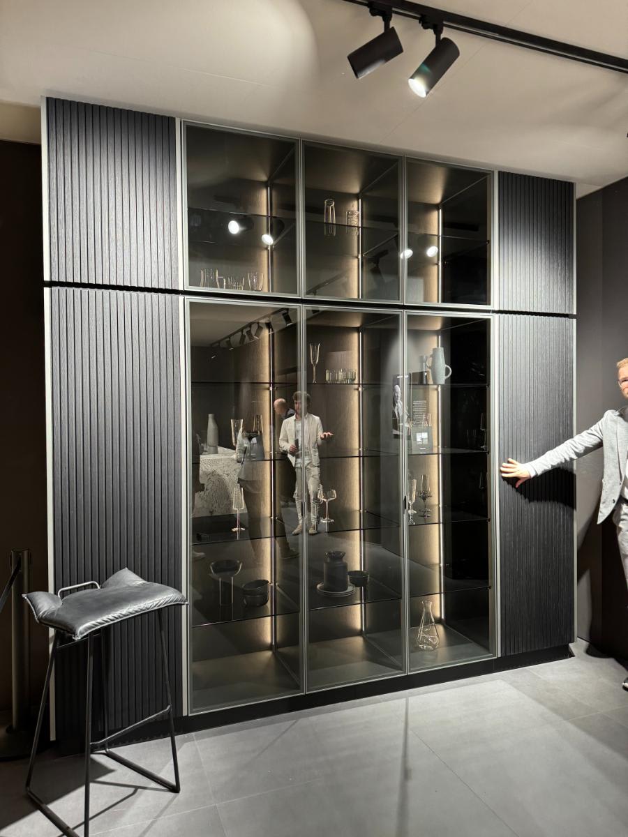 person opening eggersmann's glow cabinet using furnspin hardware by hettich with glance glass offering hidden storage and display shelving at eurocucina salone del mobile milan 2024