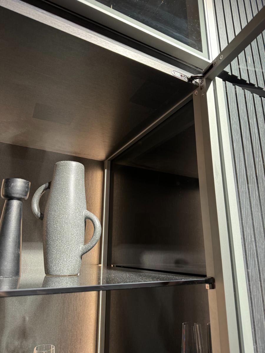 closeup of door hinge of eggersmann's glow cabinet using furnspin hardware by hettich with glance glass offering hidden storage and display shelving at eurocucina salone del mobile milan 2024