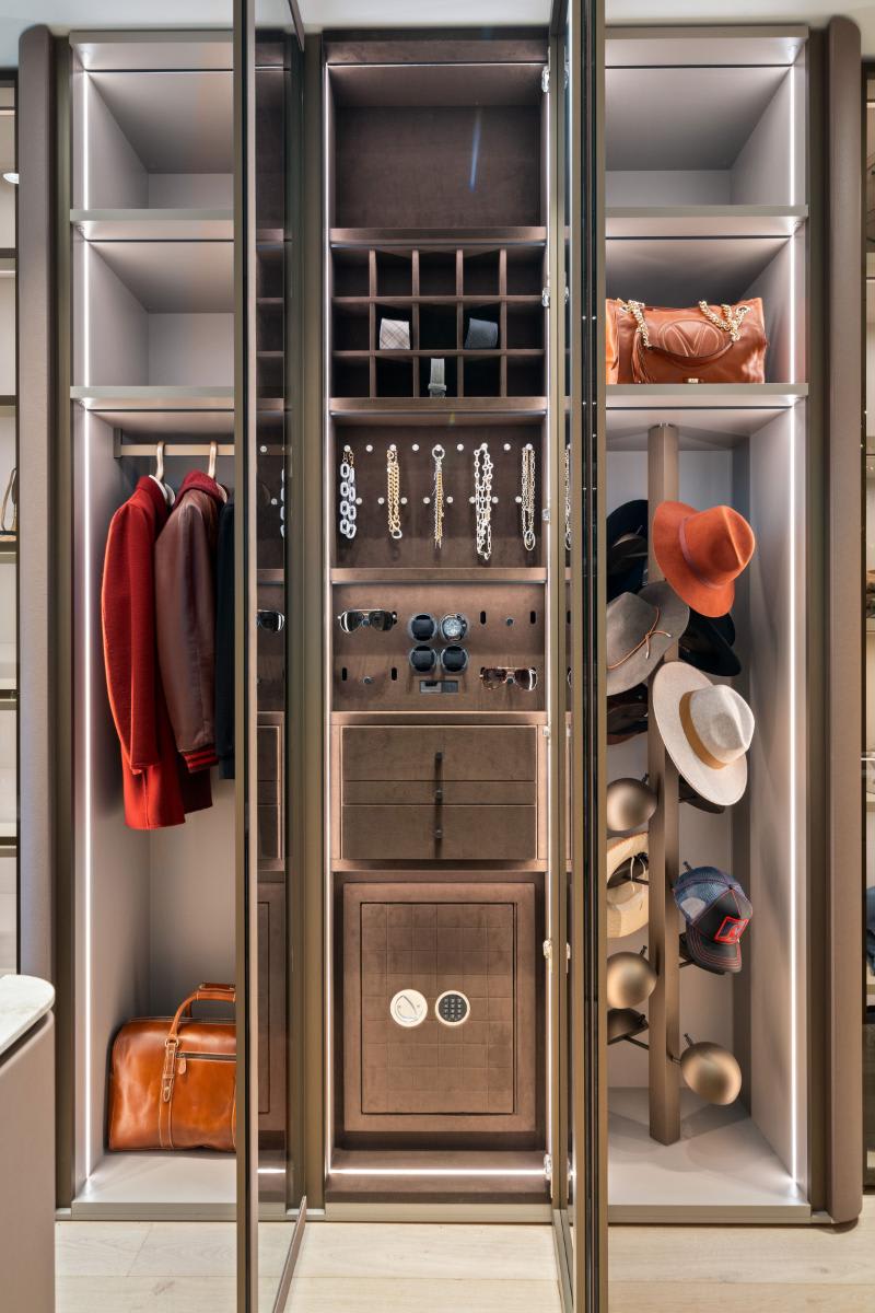 vertical glass-front cabinetry with jewelry storage, safe, and revolving hat rack