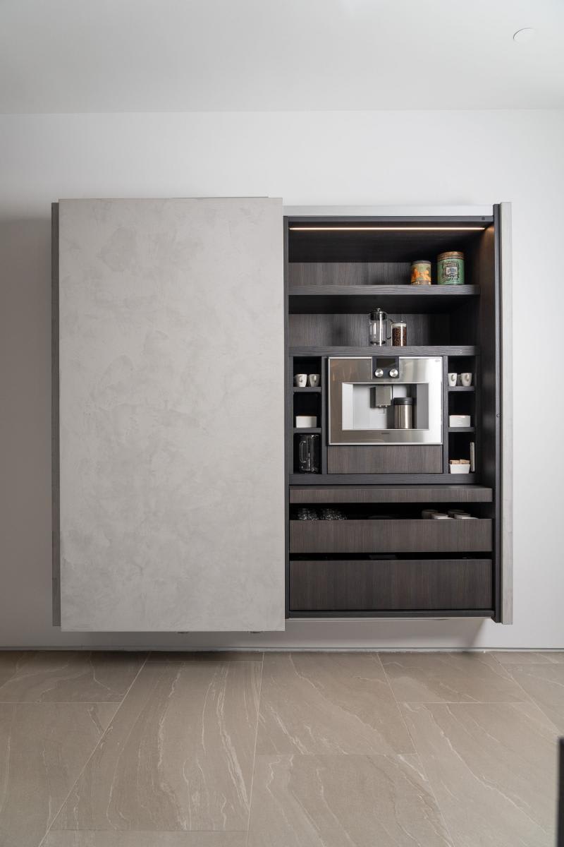 coplanar doors open on the right side revealing a coffee bar in a display kitchen in the eggersmann laguna showroom