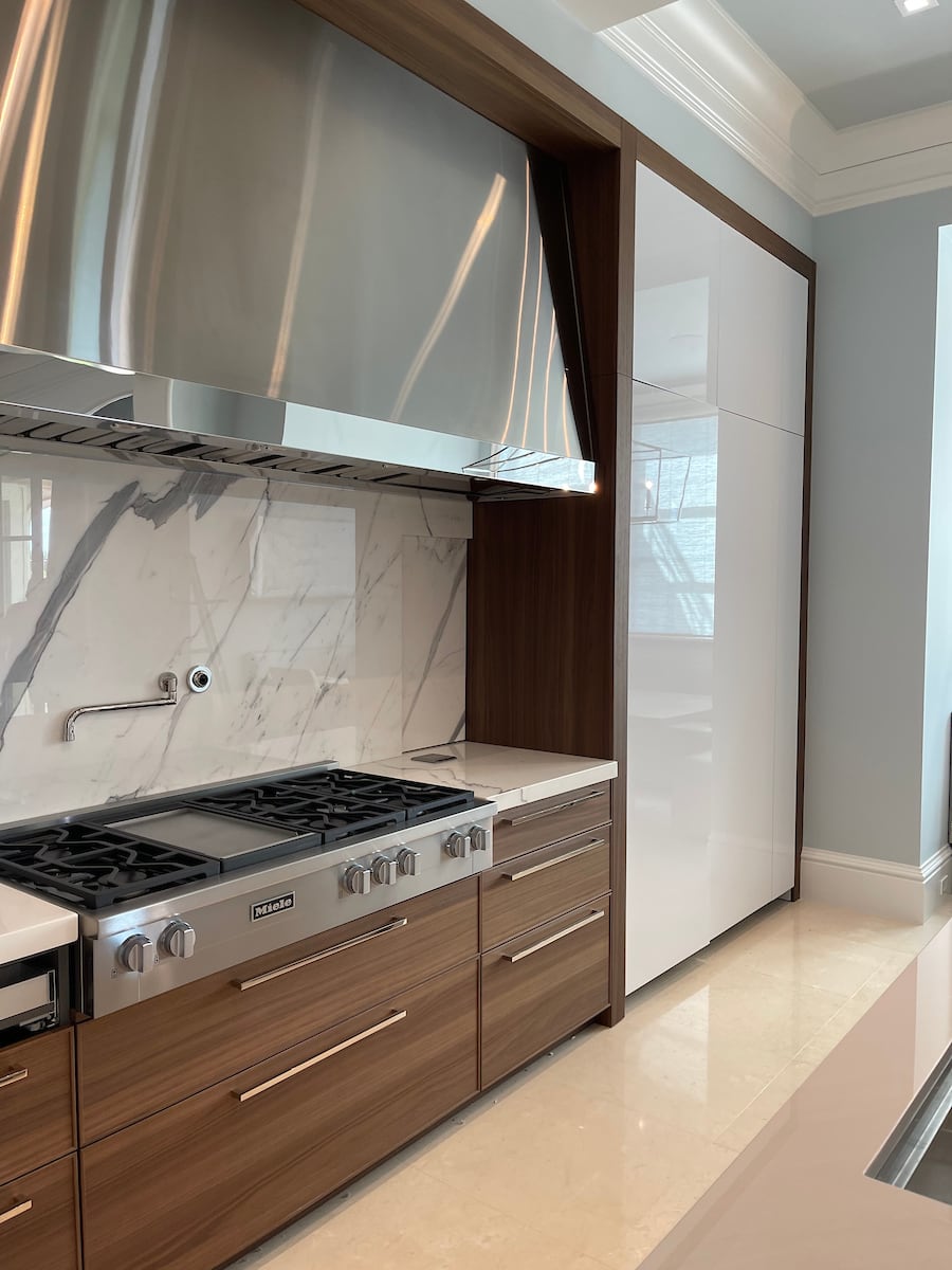A modern eggersmann usa kitchen design featuring island bar seating, Miele, Sub-Zero, and U-LINE appliances, and The Galley workstation.