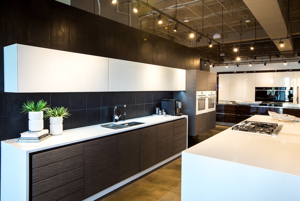 A modern eggersmann usa kitchen design featuring Miele and Thermador appliances, embossed veneer and glass finishes, and co-planar rear island storage.