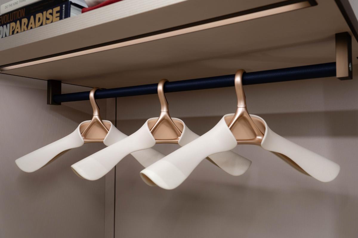 signature collection of lou hansell luxury hangers in h-series rose gold finish with nude interior and off-white exterior shoulder guards