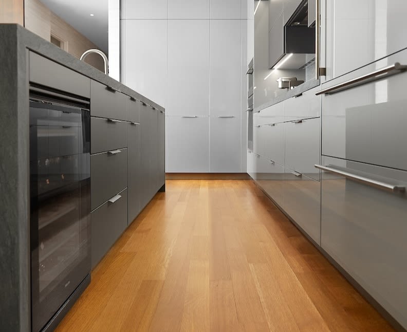 A modern eggersmann kitchen design featuring monochromatic gray and stone waterfall island. A modern eggersmann kitchen design featuring monochromatic gray and stone waterfall island.