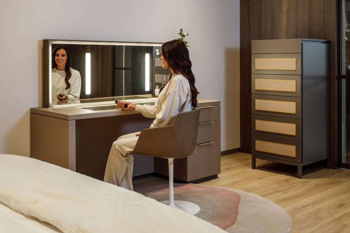 luxury bedroom display featuring a custom dressing vanity table with lowering mirror and custom chest of drawers in eggersmann houston