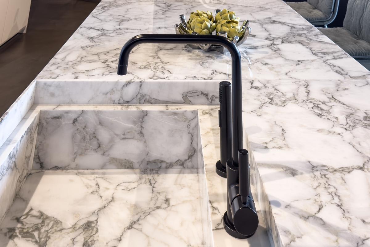 integrated stone sink in the white gloss wall cabinets and glance glass display kitchen of the eggersmann houston showroom