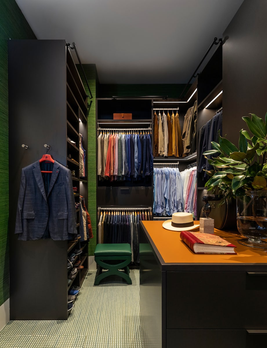 luxury walk-in closet with accents of deep green in a A modern Houston home design by eggersmann
