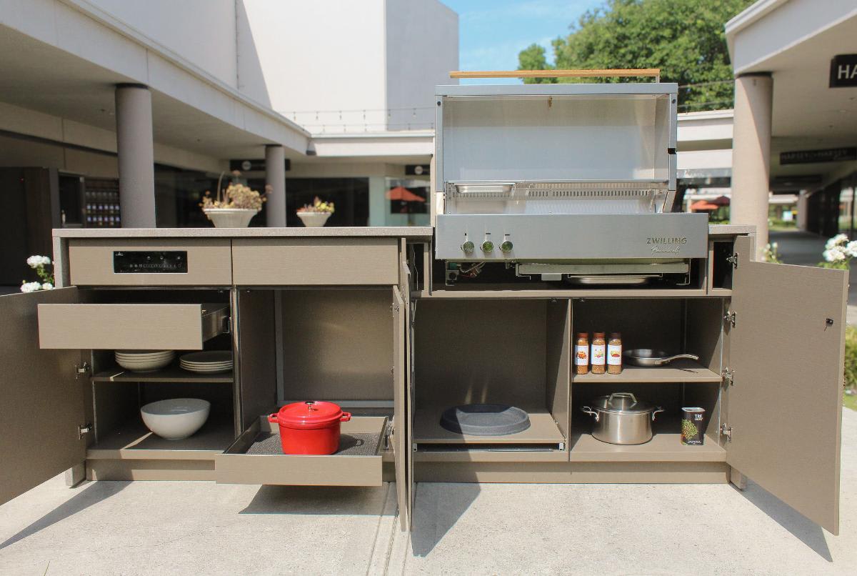 open cabinets and drawers to show storage options of a luxury outdoor kitchen island outside eggersmann Laguna showroom