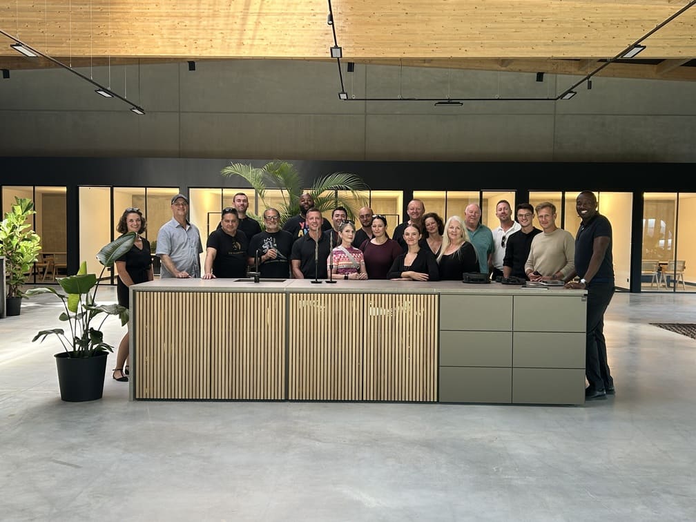 group of staff and clients posing with a c4 outdoor kitchen in the cubic outdoor living showroom in germany during a concierge trip sponsored by eggersmann