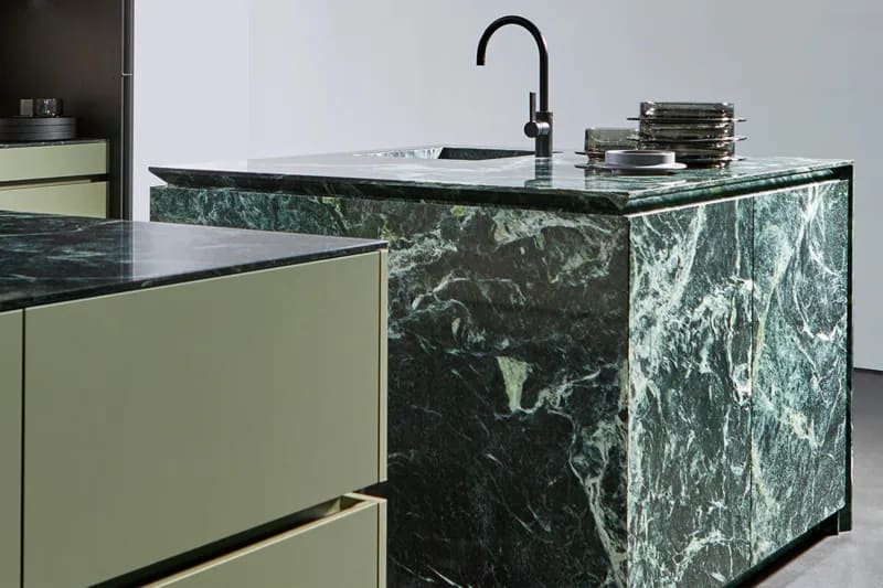 tauern green portland linoleum and stone twin kitchen islands in a display kitchen of the eggersmann germany showroom