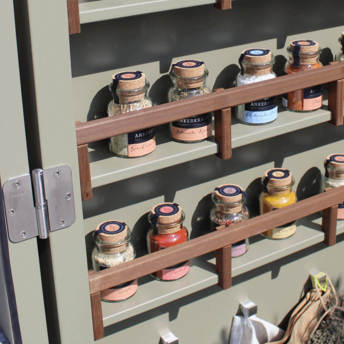 spice rack on interior cabinet door of a outdoor living kitchen in a cupboard