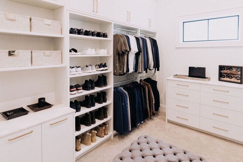 built-in cabinets and dresser with shoe shelving and hanging clothes storage in a luxury walk-in closet