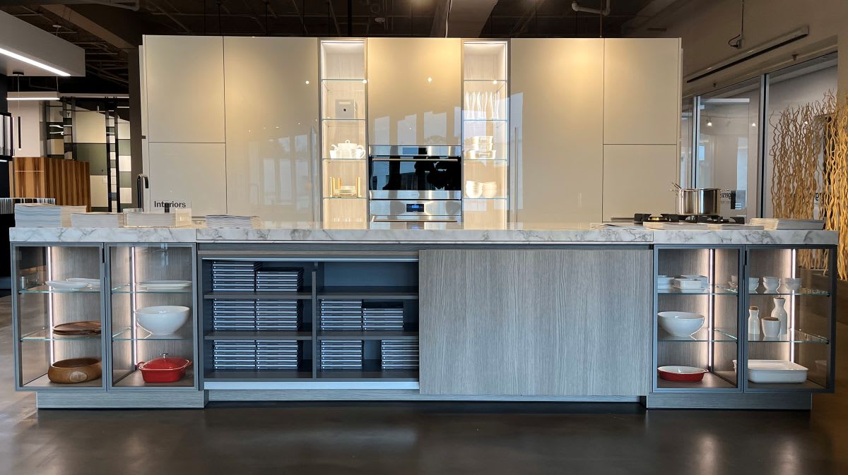 oversized kitchen island with glass-front display cases on each end and coplanar doors for hidden storage that does not open out, left side open
