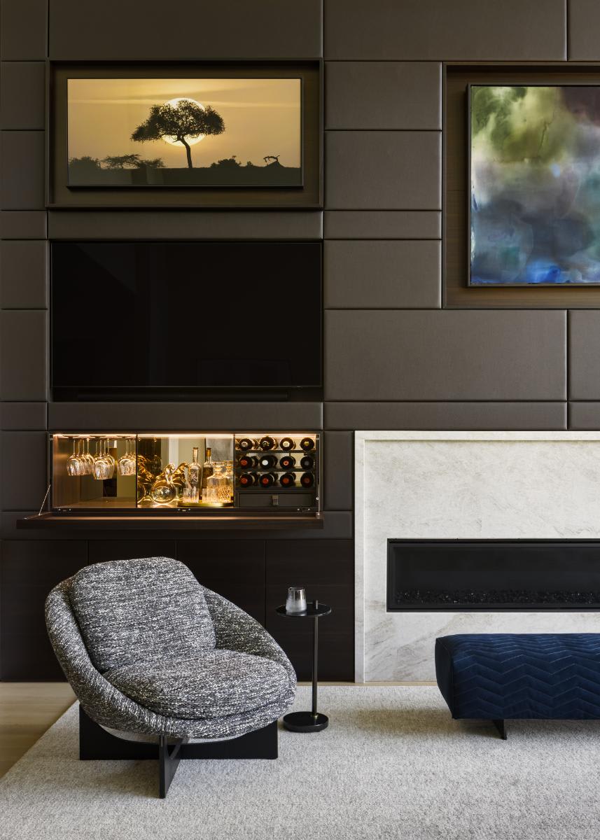 tv exposed and flip-down bar open in a eggersmann-designed media wall of a luxury home living room in a home in leawood kansas