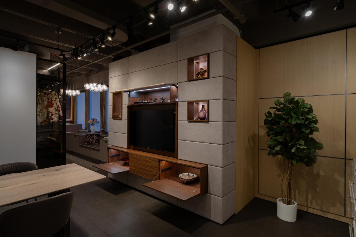 side view of a eggersmann nyc showroom media wall display with the storage and table top console open