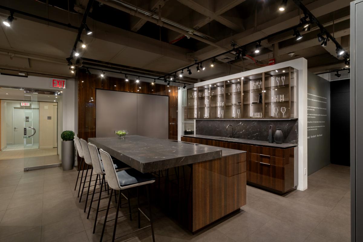 motion countertop open with barstools with glance glass front upper cabinets in a eggersmann nyc showroom display kitchen