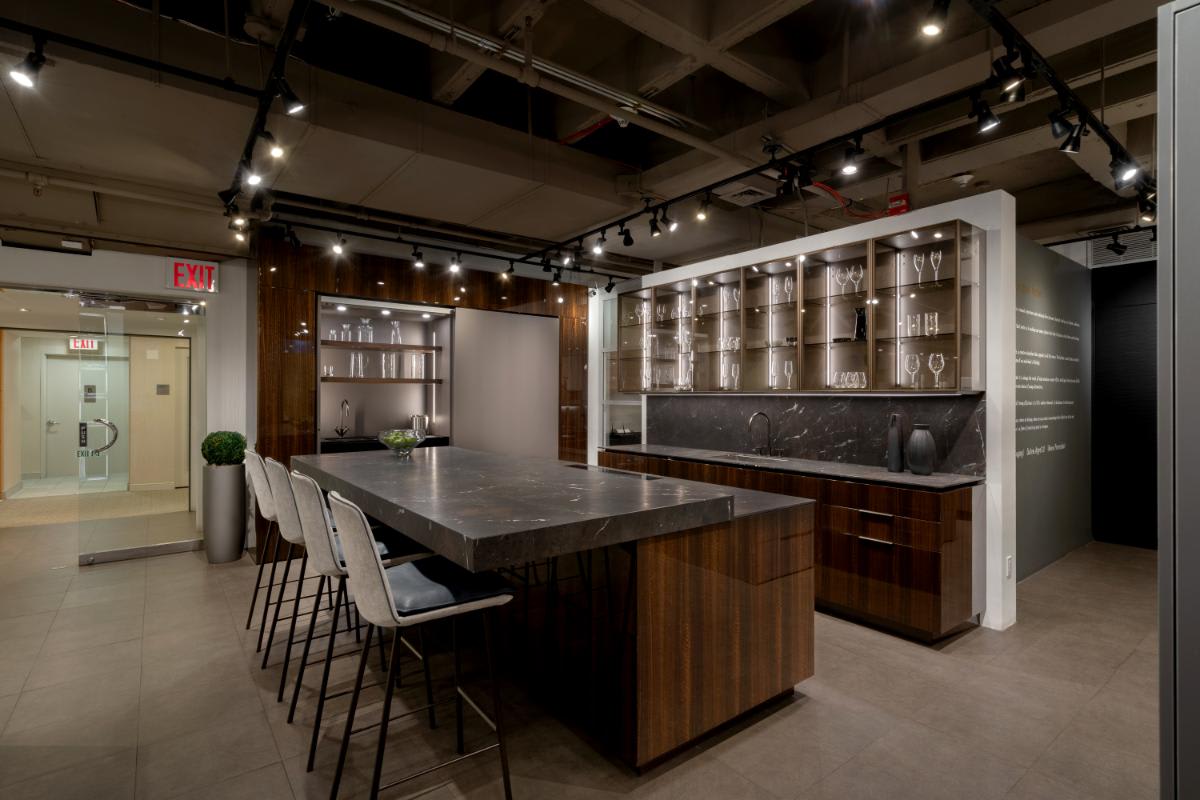 motion countertop open with barstools with glance glass front upper cabinets and coplanar door unit left side open in a eggersmann nyc showroom display kitchen