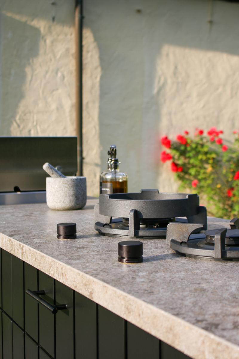 closeup of countertop-mounted wok and soup pot burners in an outdoor kitchen designed by eggersmann and custom-crafted by cubic