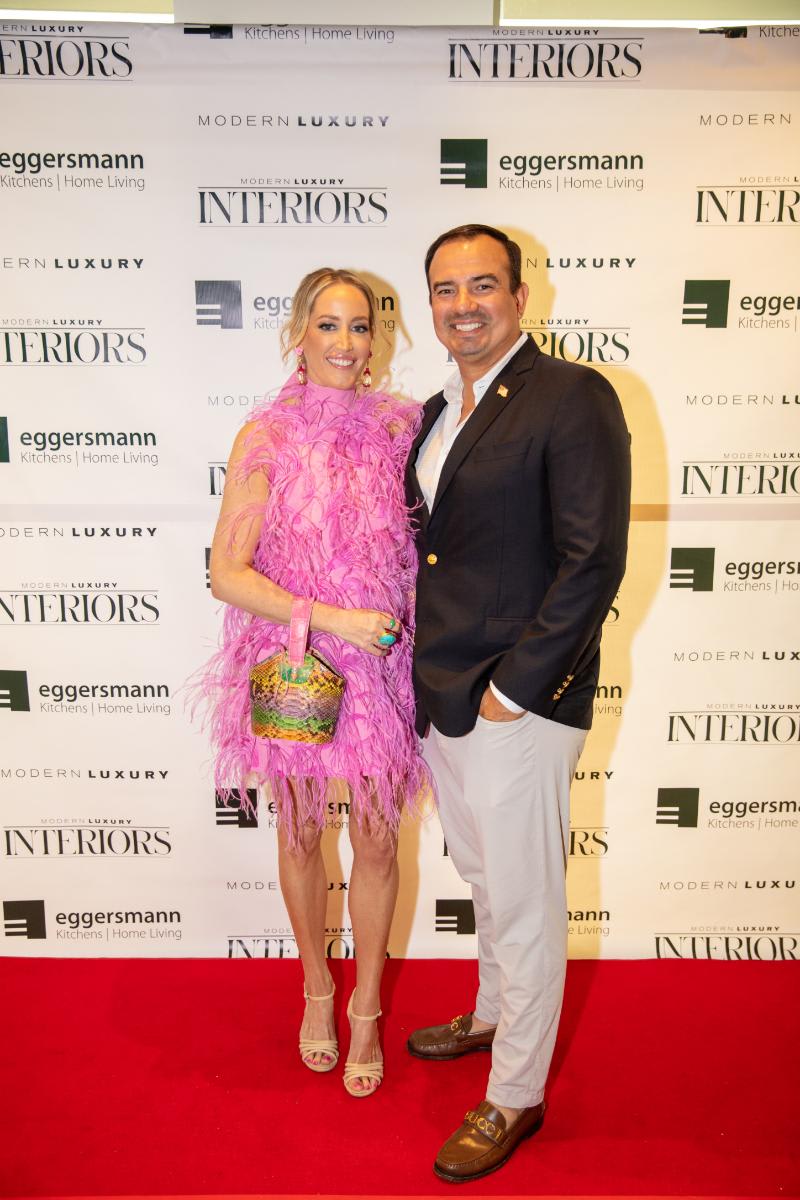 elegantly dressed attendees at the chef's night out competition at eggersmann houston's grand re-opening in front of the step-and-repeat display featuring eggersmann modern luxury interiors logos