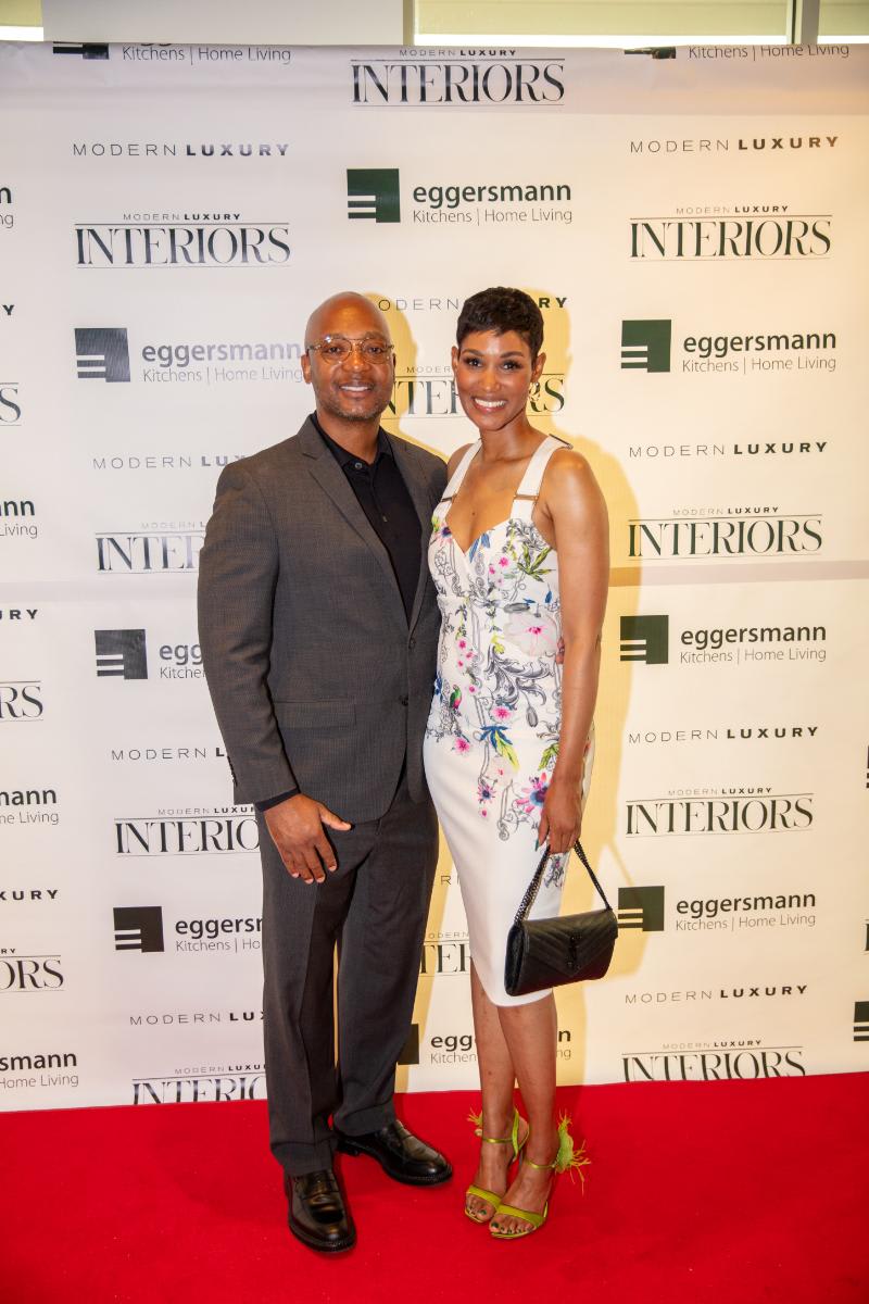 elegantly attired attendees at the chef's night out competition at eggersmann houston's grand re-opening in front of the step-and-repeat display featuring eggersmann modern luxury interiors logos