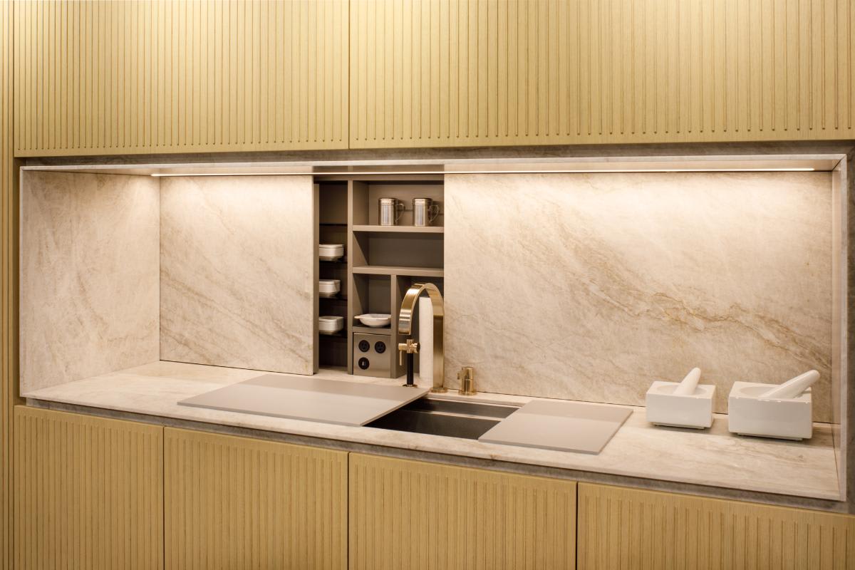 motionv sliding door closes over backsplash storage door in a kitchen display in the eggersmann houston showroom