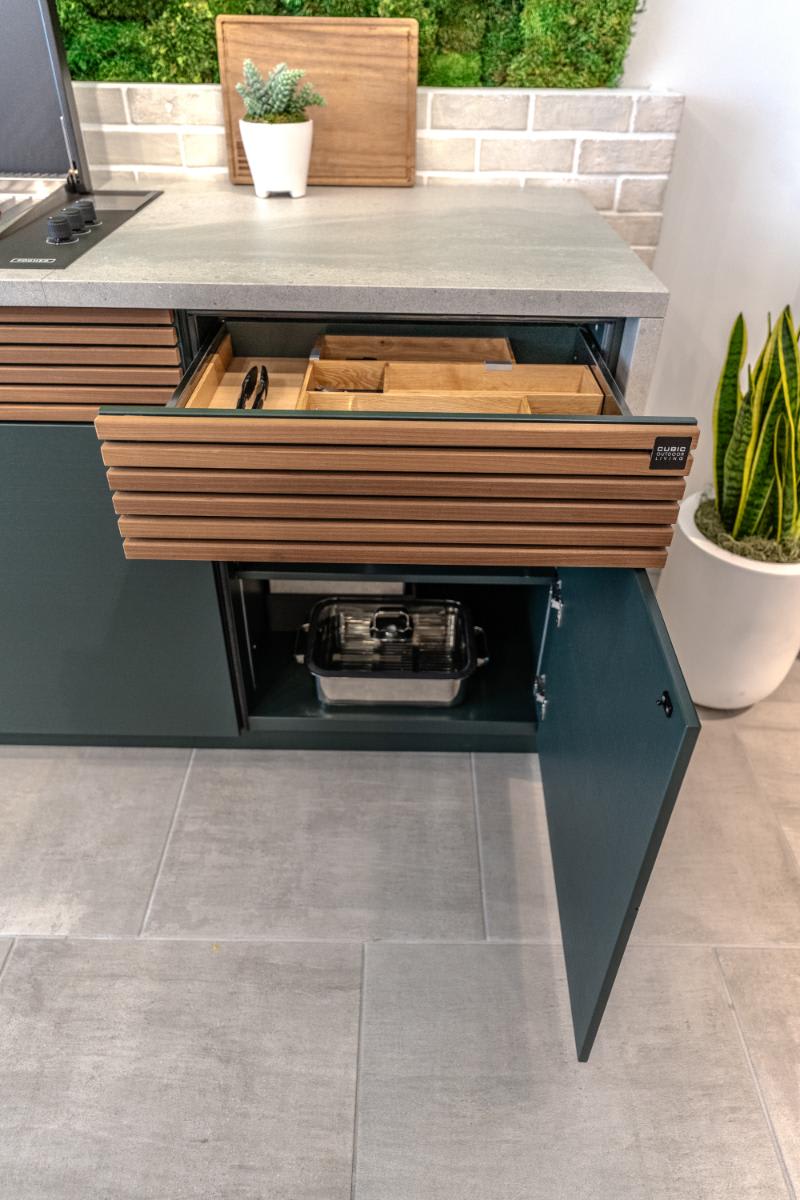 drawer and cabinet door open on the right side of the c4 kitchen island in the cubic outdoor kitchen display inside eggersmann la showroom