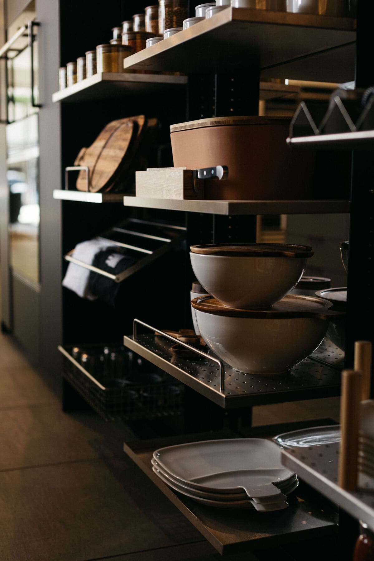 close-up of custom storage organizers for baking and cooking utensils in an open turnstile pantry in the work's pantry display with dual kitchen islands in the eggersmann la showroom