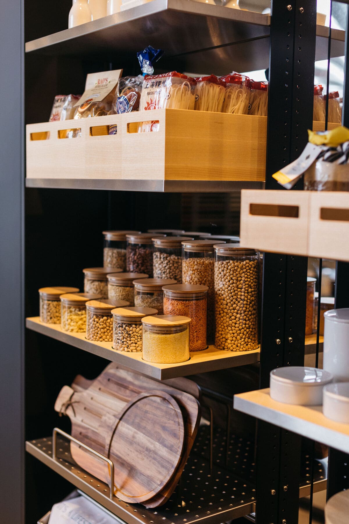 close-up of food storage boxes and jars in an open turnstile pantry in the work's pantry display with dual kitchen islands in the eggersmann la showroom