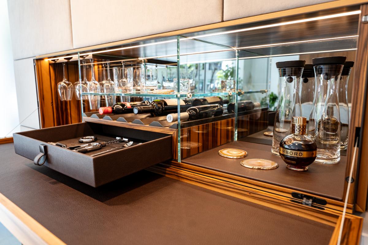 closeup of the open hidden bar's leather-wrapped accessory drawer in the living area media wall display of the eggersmann la showroom