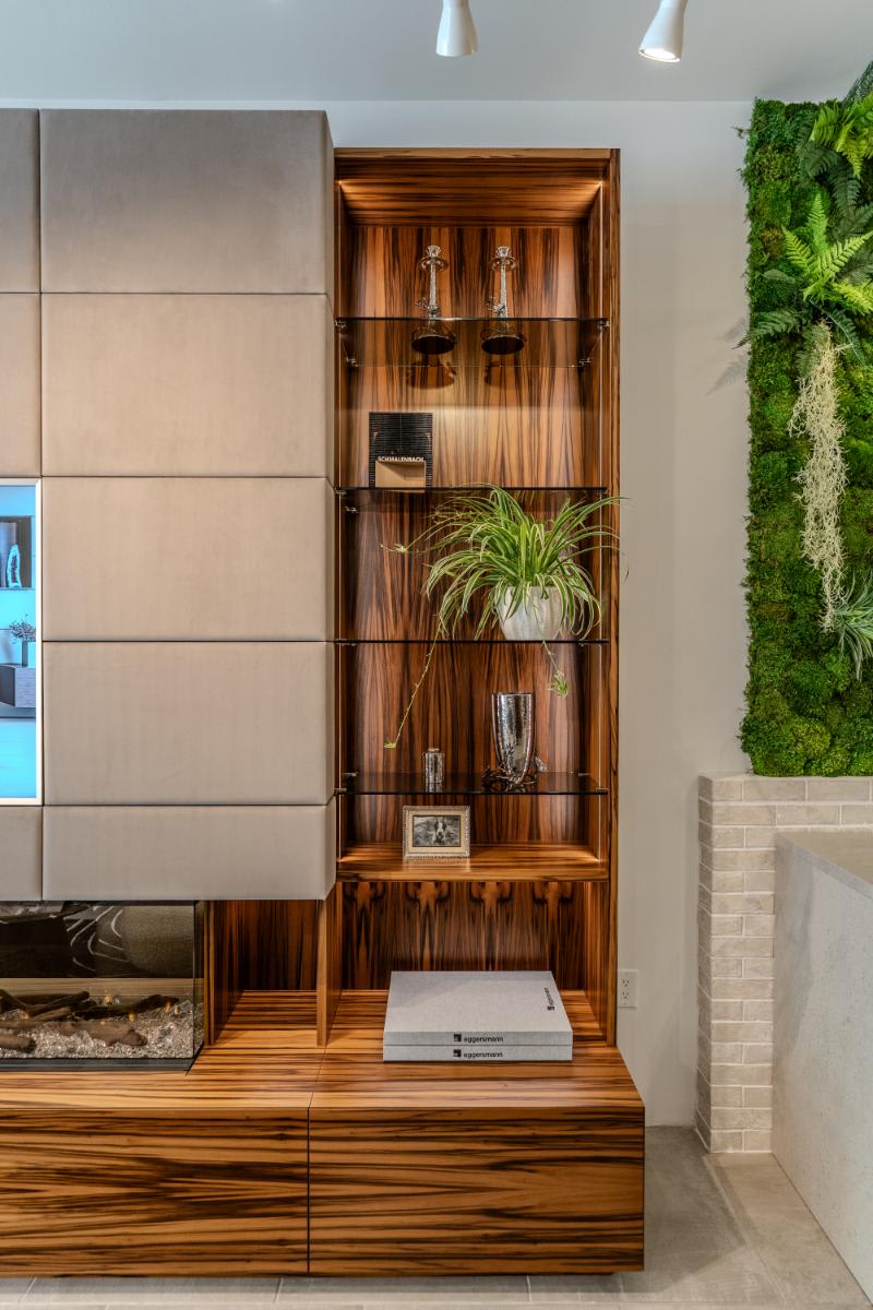 right-side display shelving with built-in led lighting in the living area media wall display of the eggersmann la showroom