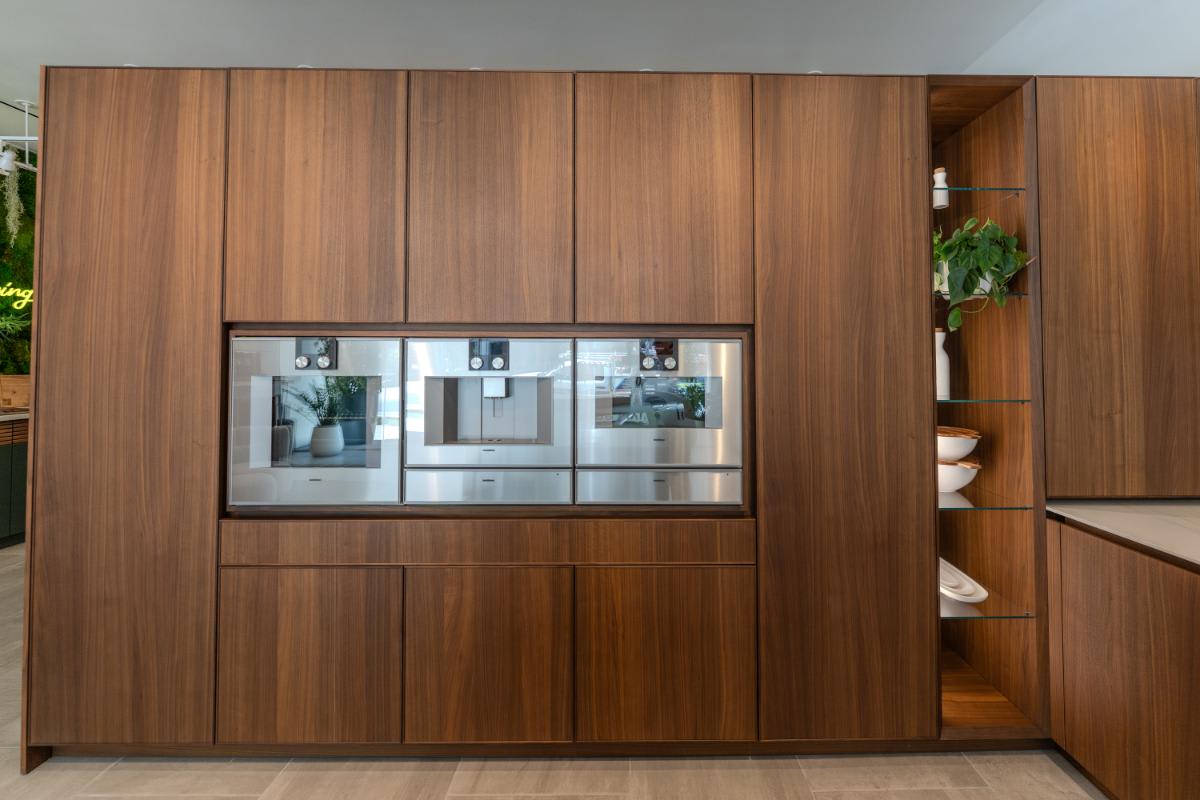 bank of tall wood veneer cabinets with gagganeau appliances