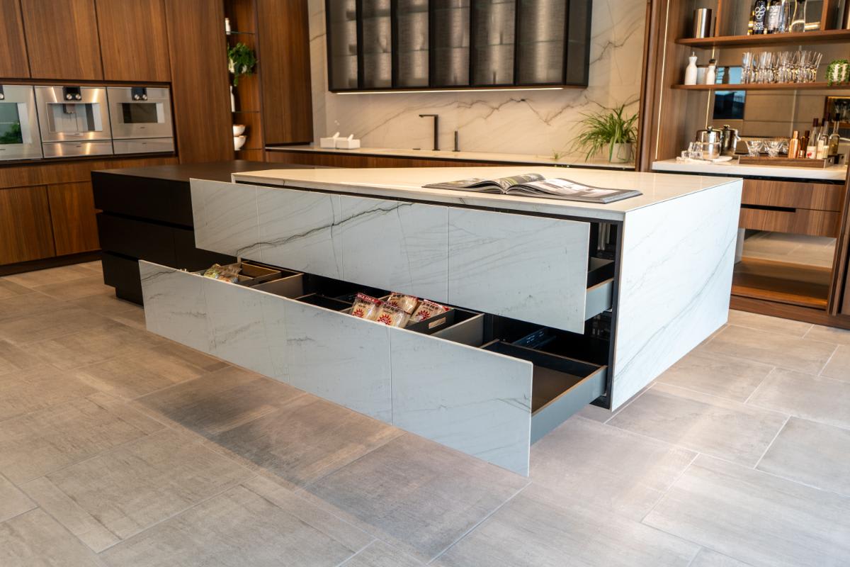 front view of drawers open in the stone section of the skywalk kitchen island from the unique cabinetry collection in the eggersmann la showroom