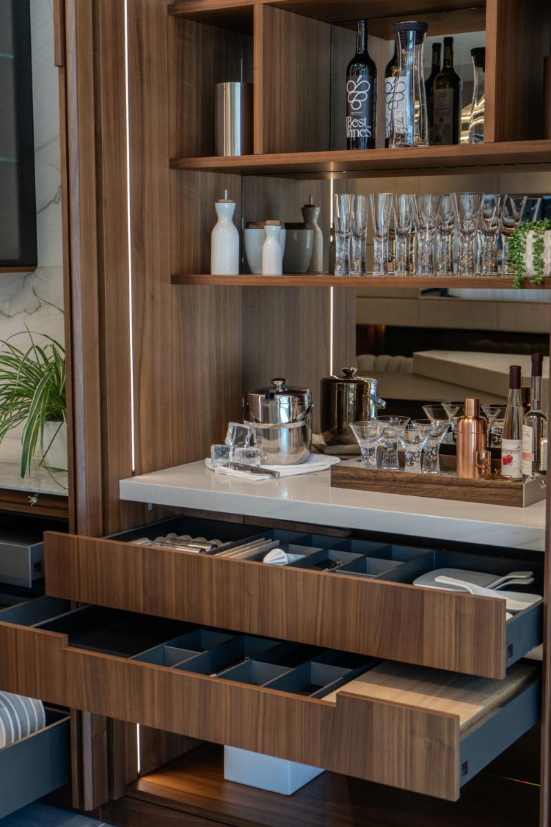 storage shelving and open drawers in the open double pocket door unit of the skywalk kitchen in the eggersmann la showroom