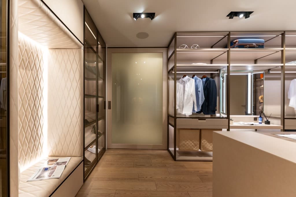 tufted upholster seating niche with built-in LED lighting and hanging storage in the walk-in wardrobe display in the eggersmann la showroom