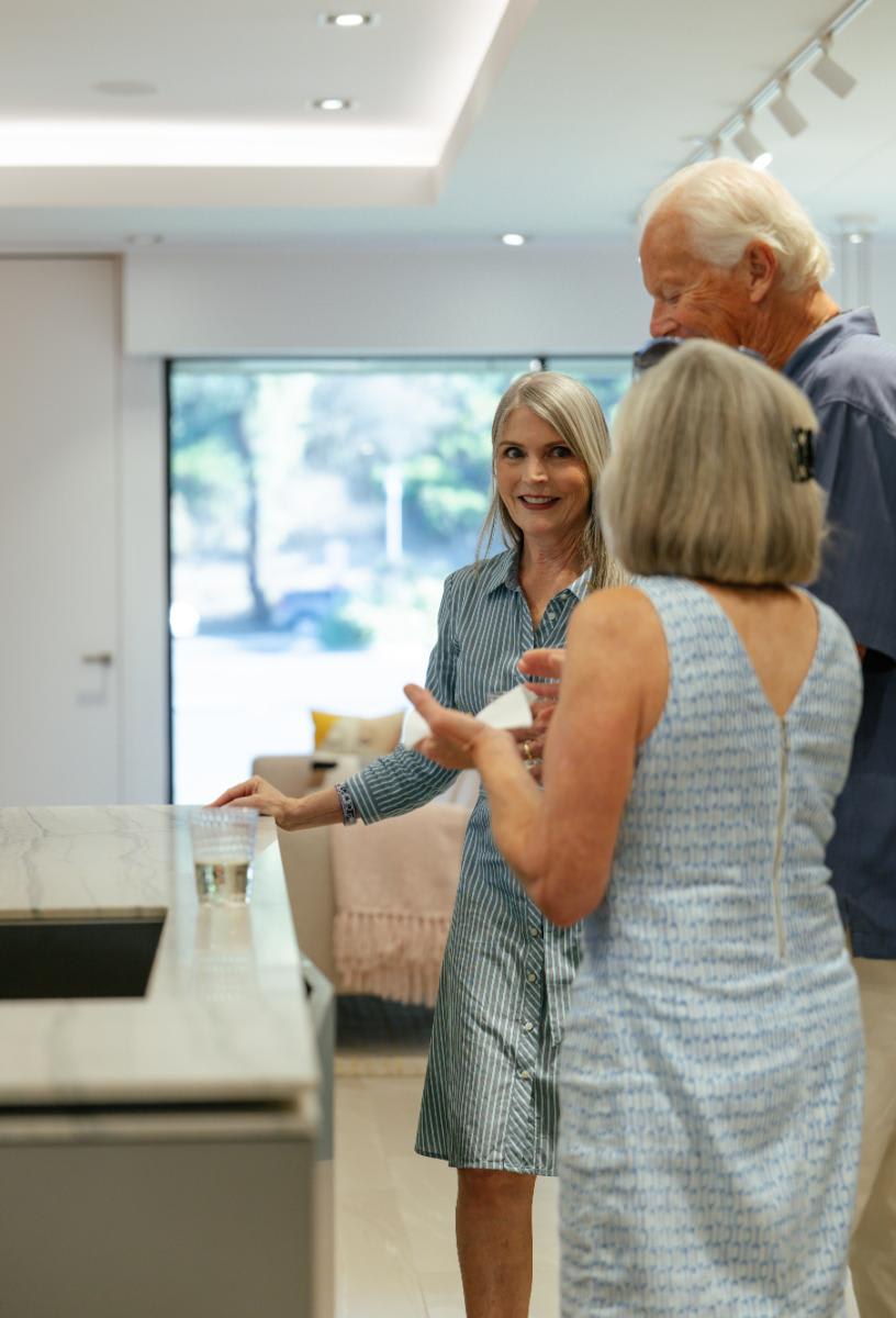 kelly lafosse, showroom manager, talks design with guests in an indoor kitchen display during the CUBIC event in august 2025 at eggersmann laguna