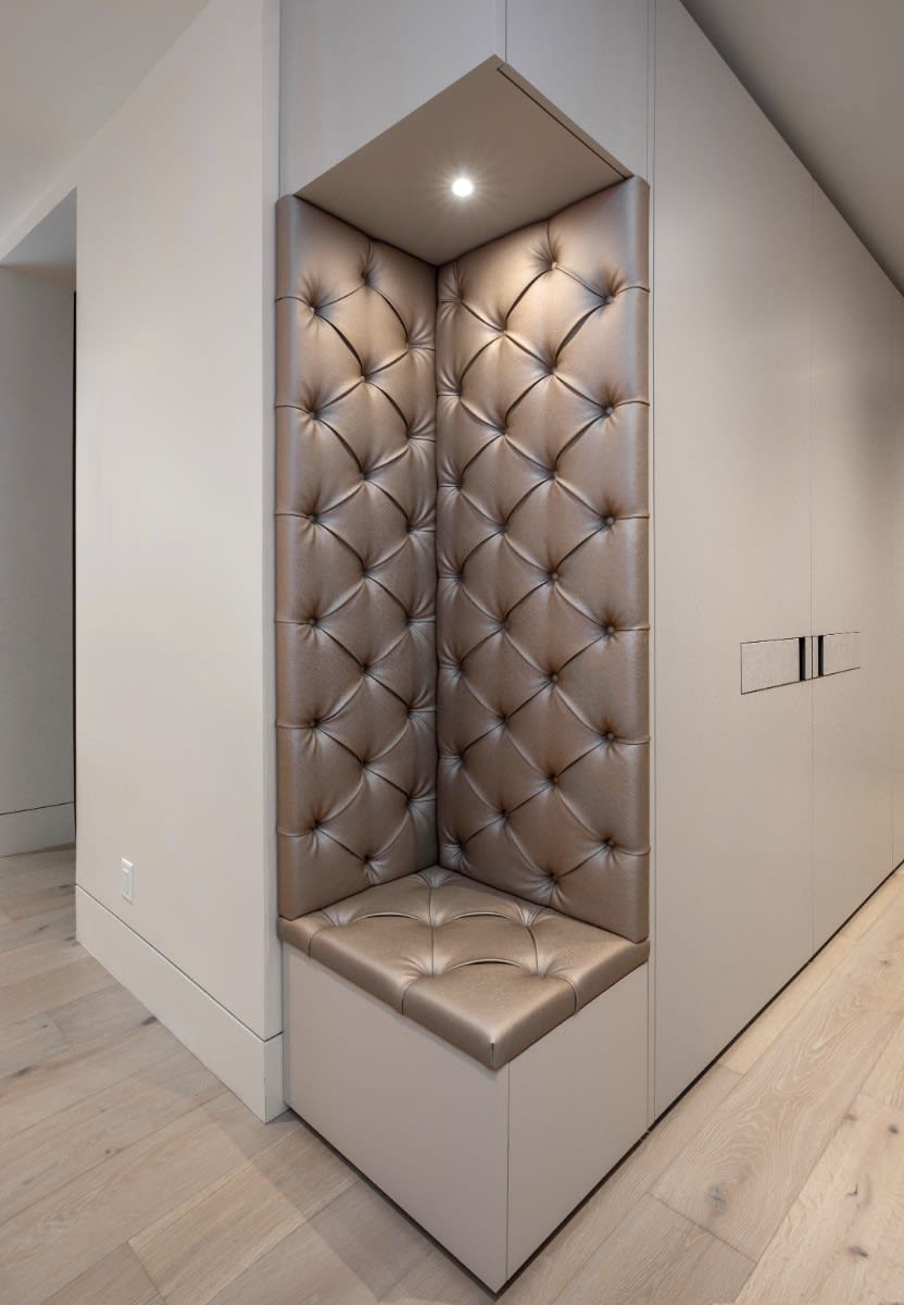 tufted-upholstered bench in a wardrobe designed by eggersmann scottsdale in a fulton ranch home