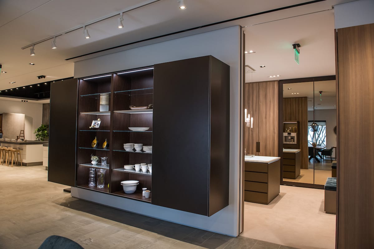 modern eggersmann usa display featuring lighted glass shelving, and sliding doors.