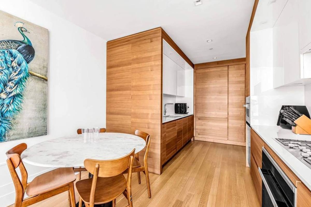 eggersmann-designed dine-in kitchen featuring wood veneer and gloss white finishes residence in 252 east 57th st of nyc